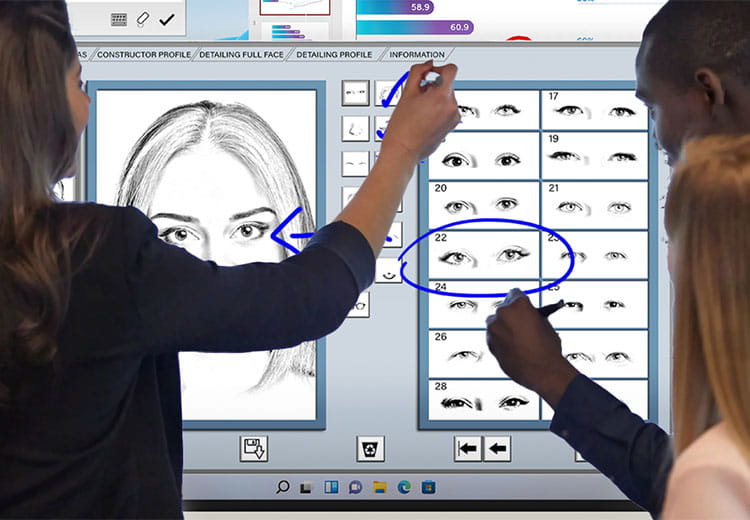 Two professionals collaborating on creating a facial composite using a SMART interactive display in a security setting.