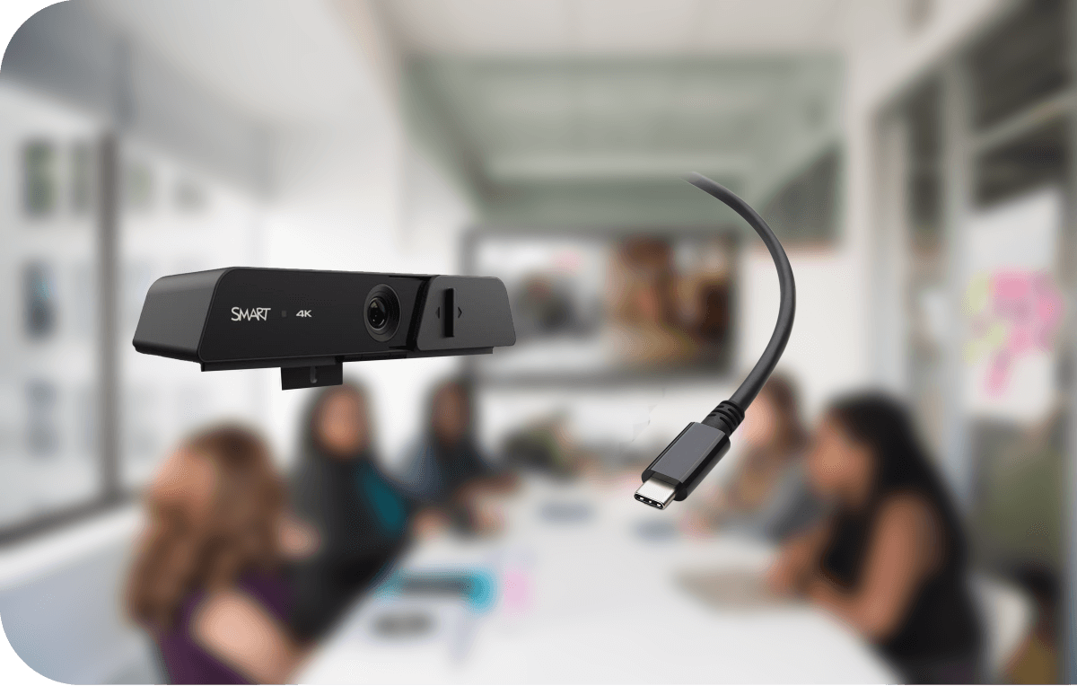 Close-up view of the SMART Ultra HD Camera 120 with a USB-C Cable 18 in focus, in a blurred meeting room environment.