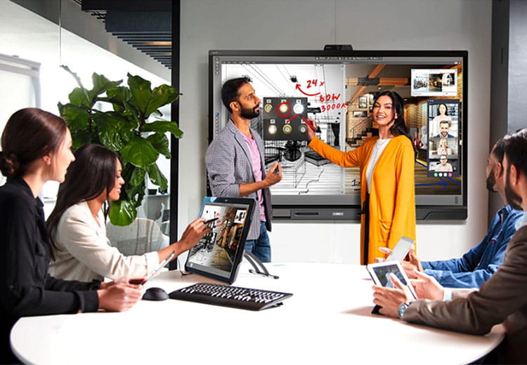A collaborative business team actively engages with a SMART Interactive display during a strategy session.